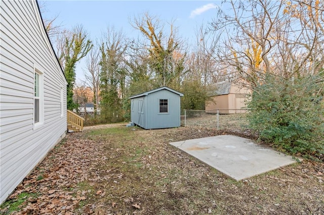 view of yard featuring a storage shed and a patio