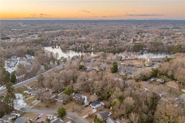 aerial view at dusk featuring a water view