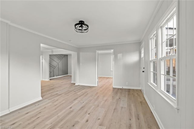 unfurnished living room featuring light hardwood / wood-style flooring and ornamental molding