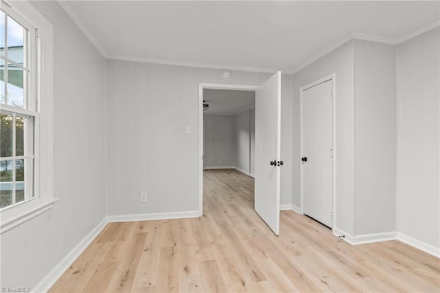 empty room featuring ornamental molding and light hardwood / wood-style flooring