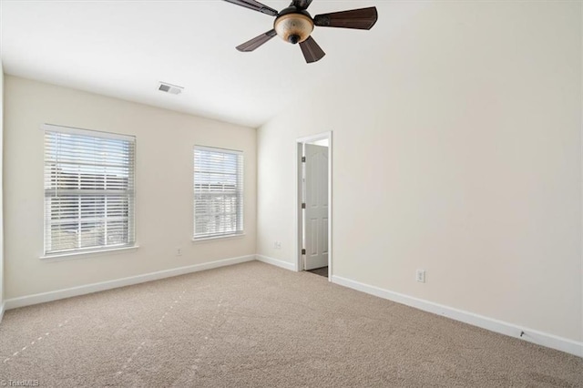 unfurnished room with light colored carpet, vaulted ceiling, and ceiling fan