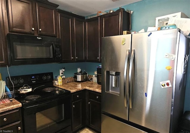 kitchen featuring dark brown cabinets, light stone counters, and black appliances