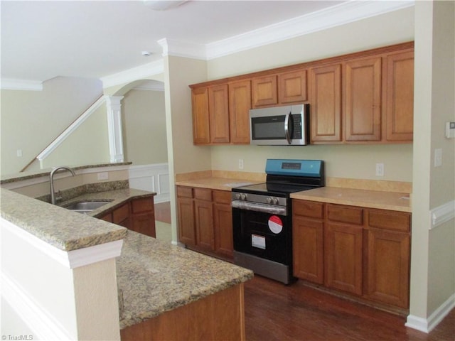 917 Avalon Acres Ct, High Point, NC 27265 - kitchen with stainless steel appliances, a sink, ornamental molding, brown cabinetry, and decorative columns