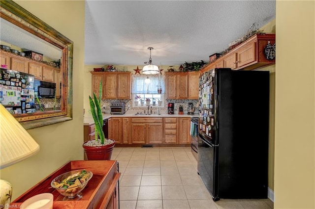 kitchen with backsplash, black appliances, sink, hanging light fixtures, and light tile patterned floors