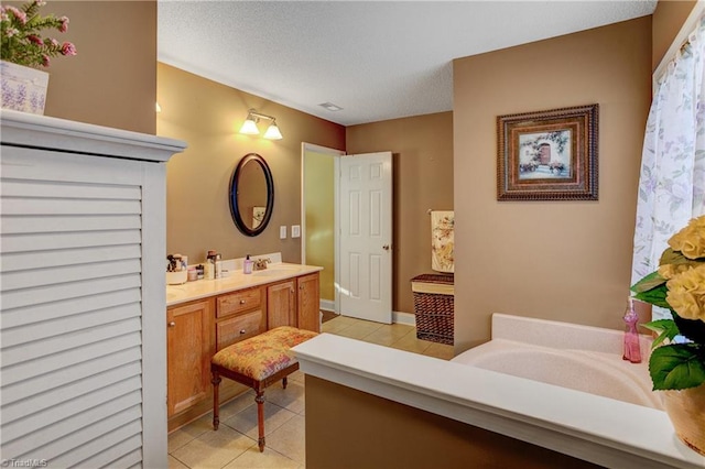 bathroom featuring tile patterned flooring, vanity, and a textured ceiling