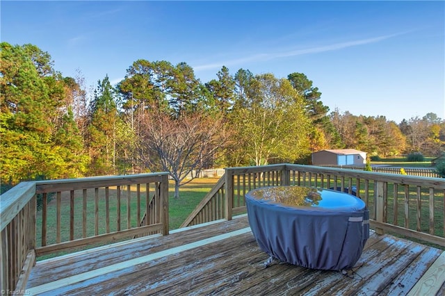 wooden terrace with a lawn and a storage unit