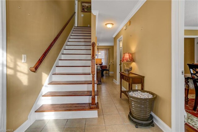 staircase with tile patterned floors and crown molding