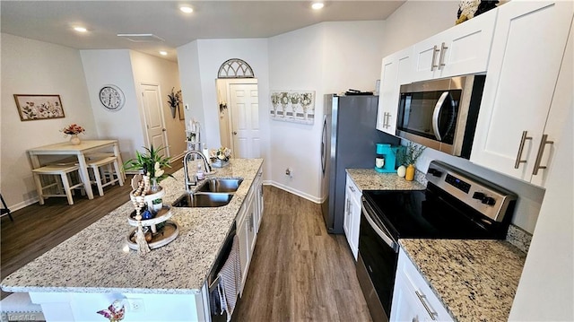 kitchen with white cabinetry, sink, stainless steel appliances, dark hardwood / wood-style flooring, and a center island with sink