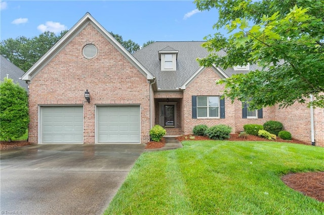2012 Muirfield Ct, Elon, NC 27244 - view of front of home featuring driveway, an attached garage, a front lawn, brick siding, and roof with shingles