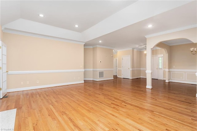 2012 Muirfield Ct, Elon, NC 27244 - unfurnished living room with crown molding, arched walkways, light wood-style flooring, recessed lighting, and a chandelier