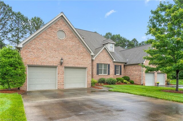 2012 Muirfield Ct, Elon, NC 27244 - traditional-style house with brick siding, concrete driveway, an attached garage, a shingled roof, and a front yard