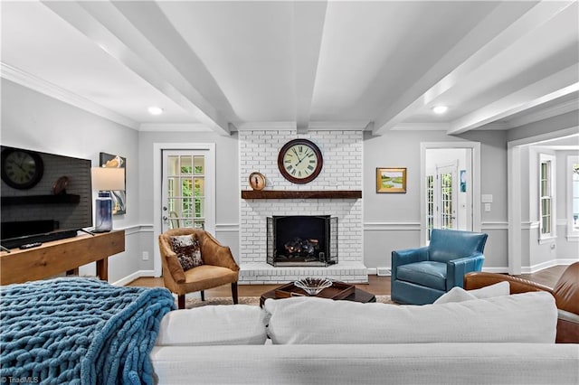 living room with wood finished floors, a fireplace, crown molding, beam ceiling, and recessed lighting