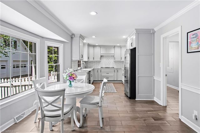 dining room featuring baseboards, dark wood-style flooring, ornamental molding, and recessed lighting