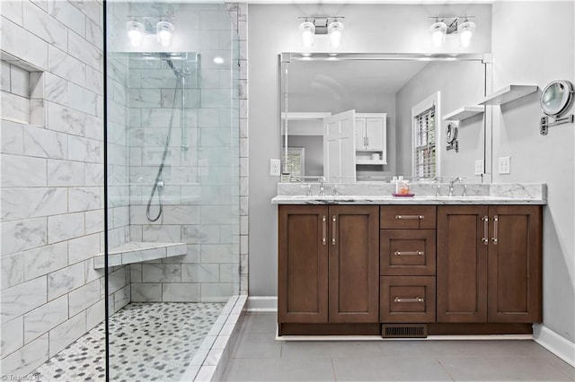 full bath with walk in shower, tile patterned floors, baseboards, and double vanity