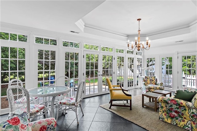 sunroom / solarium with french doors, a tray ceiling, ornamental molding, and a chandelier
