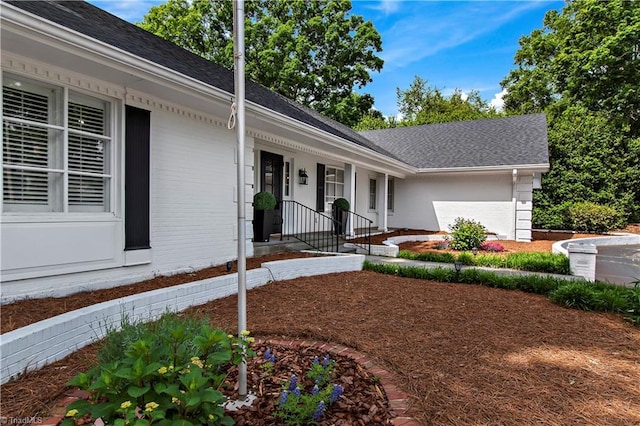 single story home featuring roof with shingles