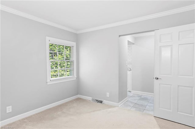 unfurnished bedroom featuring crown molding, baseboards, and light colored carpet