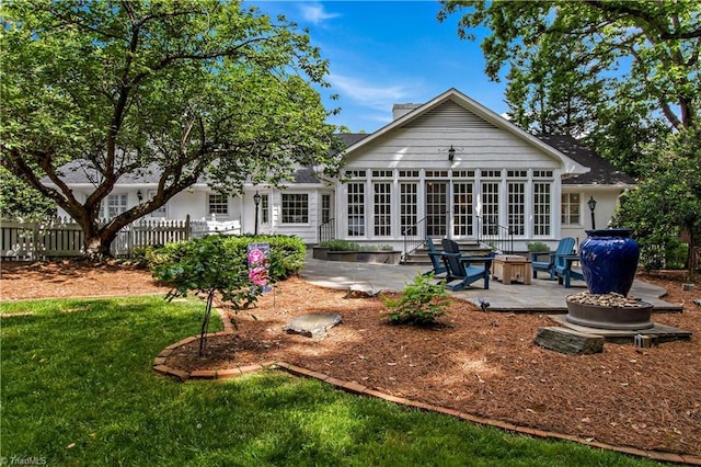 rear view of property featuring an outdoor fire pit, a patio area, french doors, and a sunroom