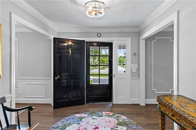 foyer with dark wood-style floors, crown molding, wainscoting, and a decorative wall