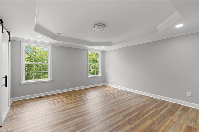 411 Motif Ln, Winston-Salem, NC 27107 - spare room featuring a tray ceiling, ornamental molding, a barn door, recessed lighting, and wood finished floors