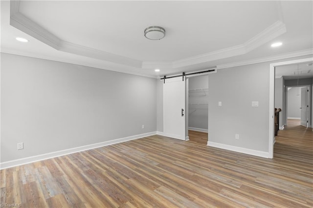 411 Motif Ln, Winston-Salem, NC 27107 - unfurnished bedroom featuring a barn door, ornamental molding, recessed lighting, a tray ceiling, and wood finished floors