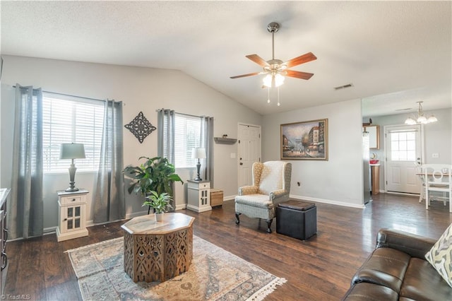 living room with ceiling fan with notable chandelier, dark hardwood / wood-style floors, and vaulted ceiling