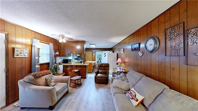 4211 Village Dr, Trinity, NC 27370 - living room featuring wooden walls, light wood-style floors, ceiling fan, and a textured ceiling