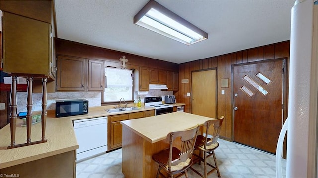 4211 Village Dr, Trinity, NC 27370 - kitchen featuring white dishwasher, range with electric stovetop, light flooring, black microwave, and wood walls