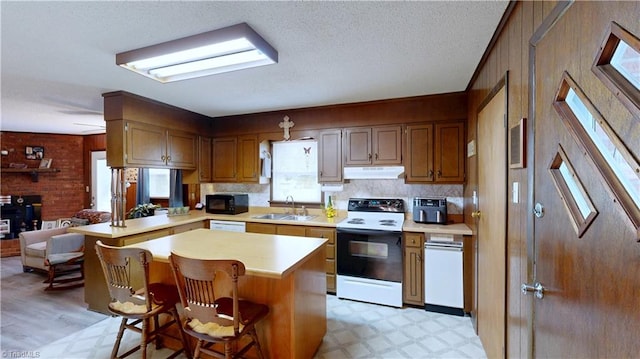4211 Village Dr, Trinity, NC 27370 - kitchen featuring range with electric cooktop, black microwave, under cabinet range hood, plenty of natural light, and a textured ceiling