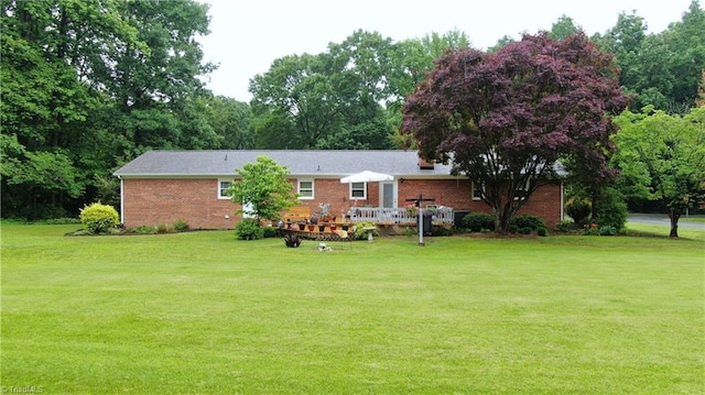 4211 Village Dr, Trinity, NC 27370 - rear view of house with a yard, brick siding, a deck, and view of scattered trees