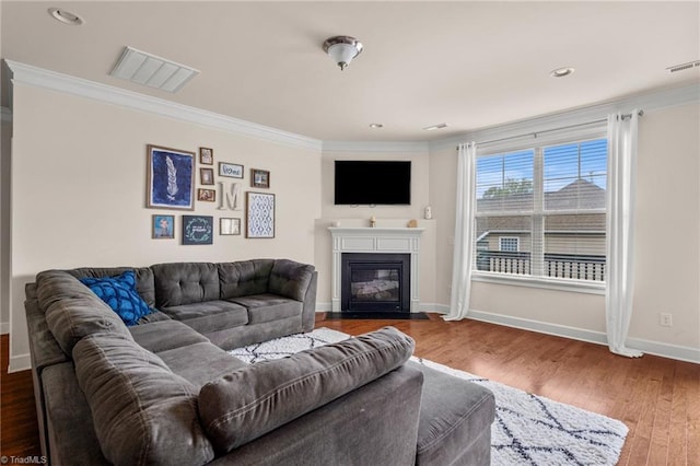 living room with hardwood / wood-style flooring and crown molding