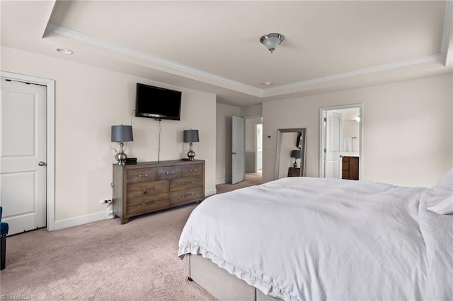 bedroom featuring a tray ceiling, ensuite bathroom, and light carpet