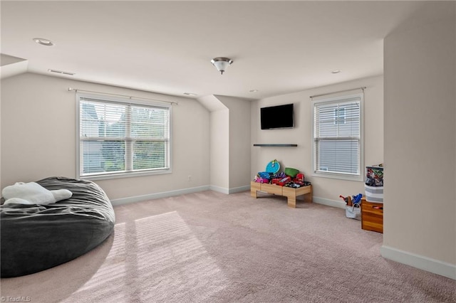 recreation room featuring light colored carpet and vaulted ceiling