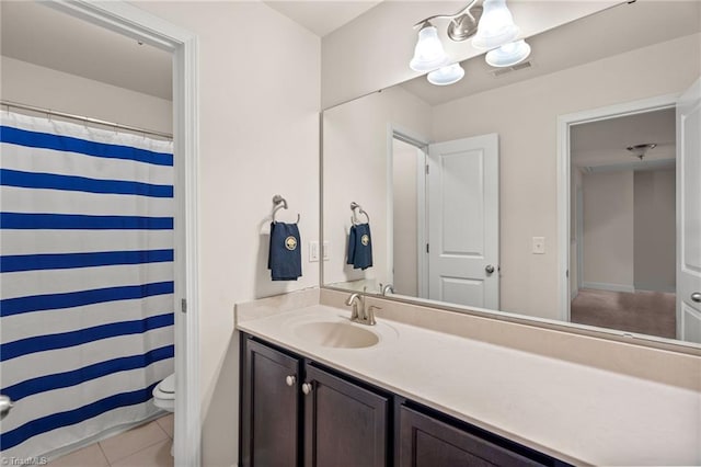 bathroom with tile patterned flooring, vanity, a chandelier, and toilet