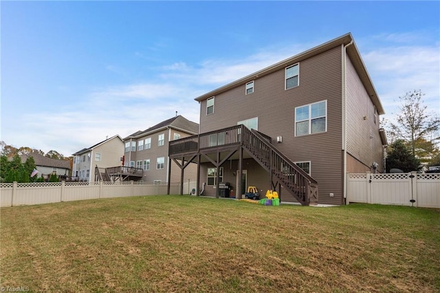 rear view of property with a lawn and a wooden deck