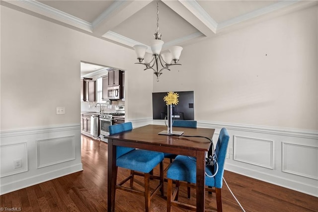 dining room featuring coffered ceiling, crown molding, sink, a notable chandelier, and beamed ceiling