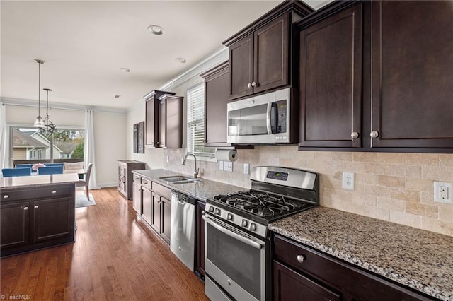 kitchen with light stone counters, sink, stainless steel appliances, and dark hardwood / wood-style floors