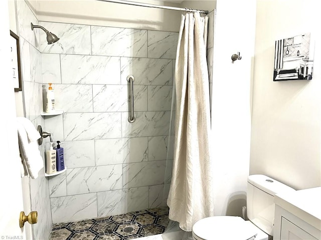 bathroom featuring a stall shower, vanity, and toilet