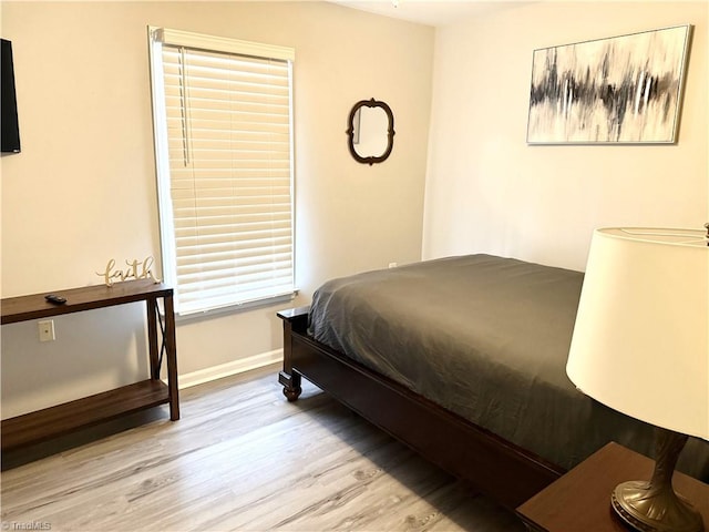 bedroom featuring baseboards and wood finished floors