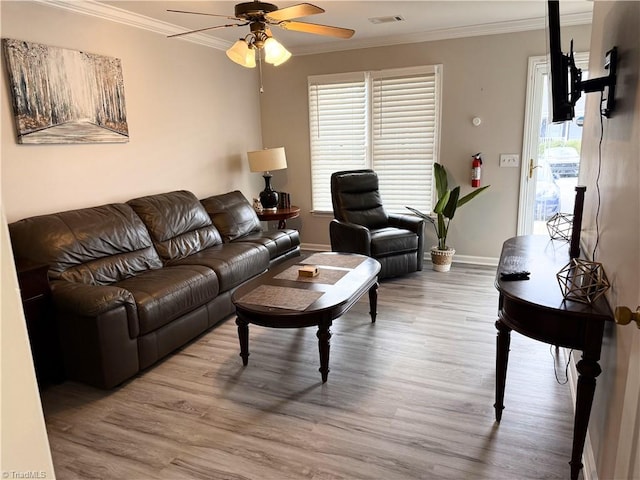 living area with visible vents, ornamental molding, and wood finished floors