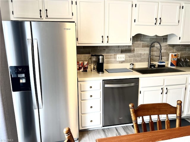 kitchen with stainless steel appliances, white cabinets, and a sink