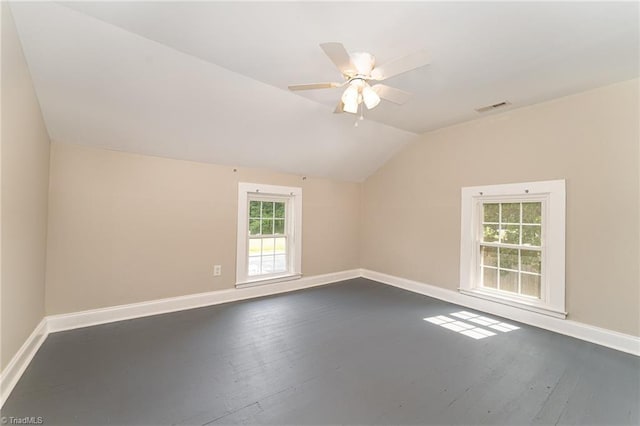 bonus room featuring ceiling fan, dark wood-type flooring, a healthy amount of sunlight, and vaulted ceiling