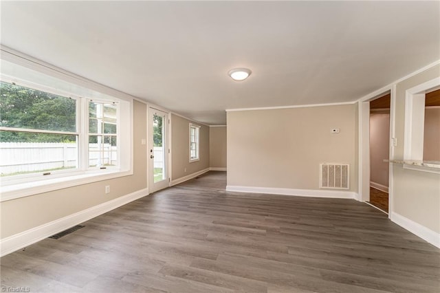 spare room featuring dark hardwood / wood-style flooring and crown molding