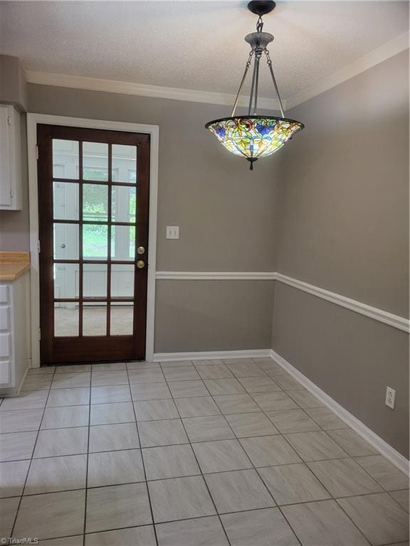 4001 S Bend Dr Unit 101, Winston-Salem, NC 27107 - unfurnished dining area with crown molding, baseboards, and light tile patterned floors