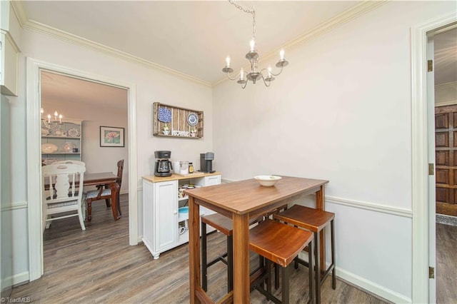 dining space featuring a notable chandelier, ornamental molding, and hardwood / wood-style floors