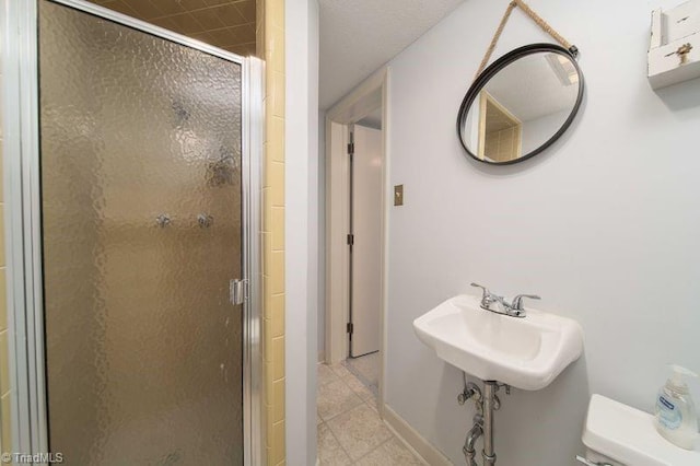 bathroom featuring an enclosed shower, sink, and toilet