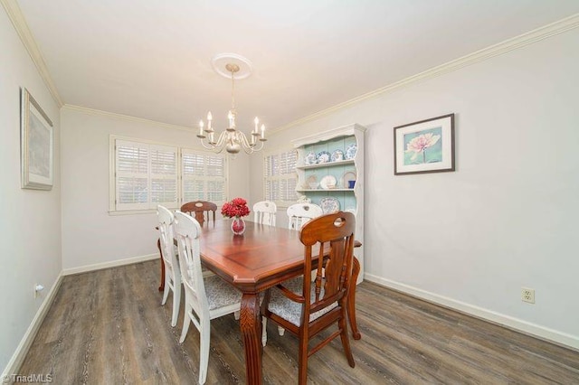 dining space featuring dark hardwood / wood-style flooring, crown molding, and a chandelier