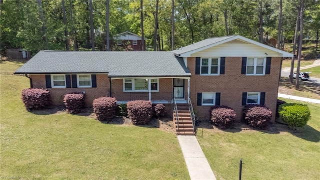 split level home with a front lawn, brick siding, and stairs