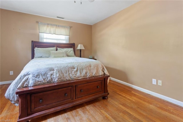 bedroom featuring visible vents, light wood finished floors, and baseboards