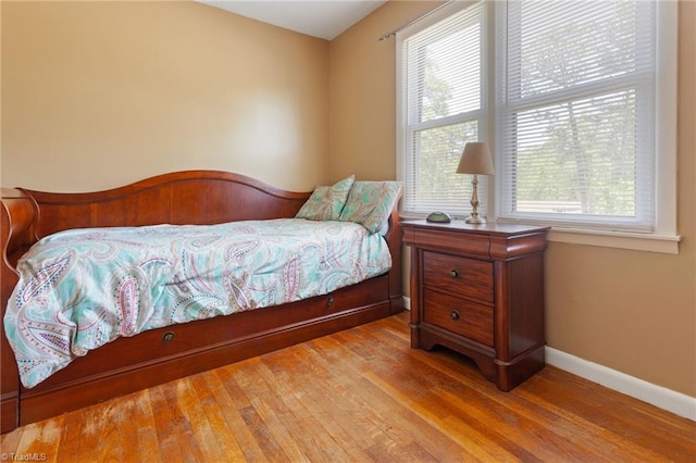 bedroom with wood finished floors and baseboards